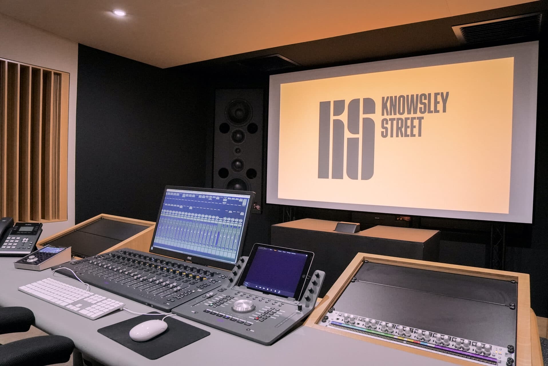 Close-up of the mixing console and monitor setup at Clicks Production studio